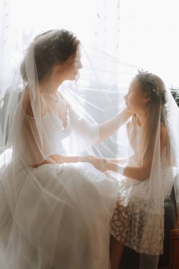 Gelin ve kız kardeşi peçenin altında birbirlerine bakıyorlar.
