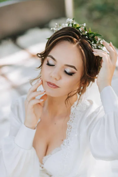 木の下の庭のベッドの花嫁の肖像画 花嫁は白いドレスと彼女の頭に新鮮な花のティアラを着ています — ストック写真