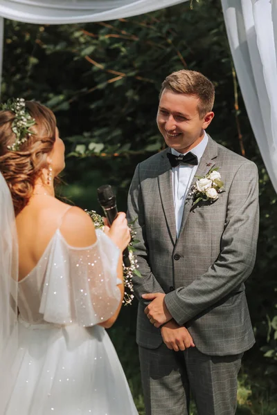Beautiful wedding couple at a summer wedding ceremony. Wedding vows, emotions and tears