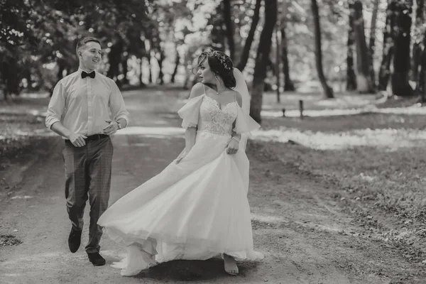 Een Bruidspaar Een Gelukkige Bruid Bruidegom Rennen Het Park Naar — Stockfoto