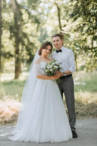 新鮮な花のティアラとファッショナブルなグルームとかわいい花嫁 公園で笑い 屋外の森 結婚式の写真 新婚旅行の笑顔の肖像画 — ストック写真