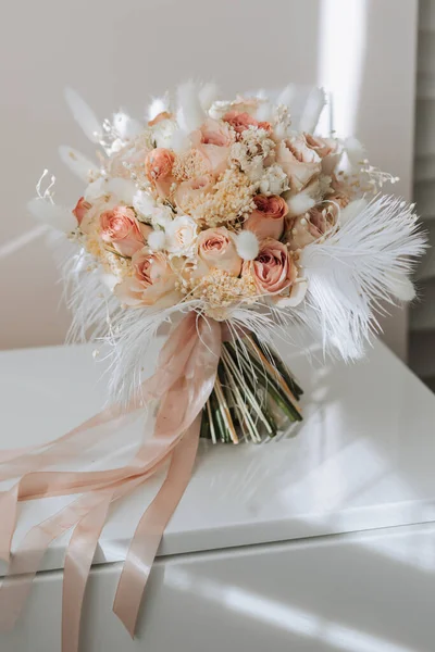 婚礼花束 粉红色的玫瑰 羽毛和干枯的花朵放在木制的看台上 — 图库照片