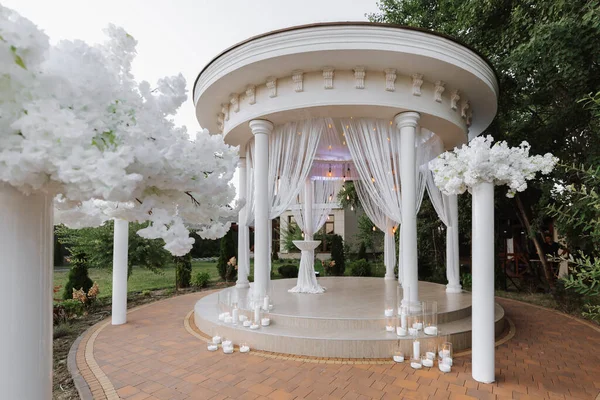 公园里封闭的婚礼拱门是由白色柱子上的白花做成的 离别婚礼 — 图库照片