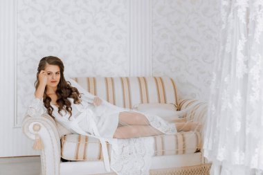 Beyaz etekli güzel bir gelin kanepede yatıyor. Düğün için son hazırlıklar. Gelin, damadı bekliyor. Günaydın, gelin..