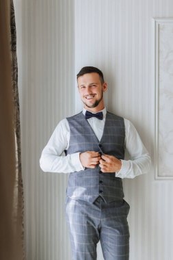 Sakallı şık bir damat düğün törenine hazırlanıyor. Damat sabahı. Bir iş adamı gri bir yelek giyer. Damat düğün töreninden önce hazırlanıyor.