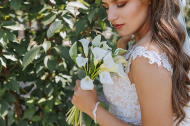 Gelinin buketli kesilmiş portresi. Genç ve güzel bir gelin elinde bir buket düğün çiçeği tutuyor. Boş alan