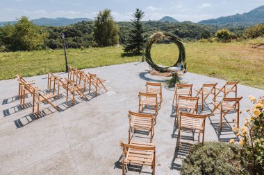 Parktaki düğün kemeri, ormanın arka planındaki kuru sazlardan bulanık bir odak noktasında yapılmıştır. Düğün seremonisi. Tören için süslenmiş sandalyeler.