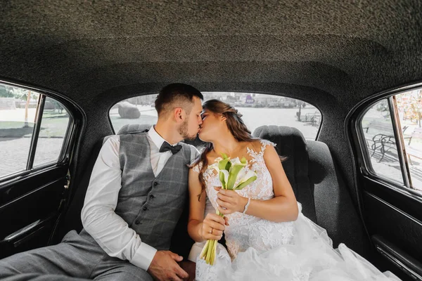 若い幸せな花嫁と彼らの車で成長し 結婚式の後に喜んでキス — ストック写真