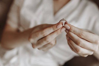 Fransız manikürlü bir kadının parmaklarında elmas olan altın bir yüzüğe yaklaş. Aşk, ilişki ve düğün kavramı. Yumuşak ve seçici odaklanma. Boş alan