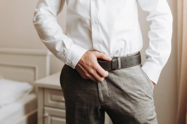 Sakallı şık bir damat düğün törenine hazırlanıyor. Damat sabahı. İş adamı beyaz gömlek giyer, damat düğün töreninden önce hazırlanır.