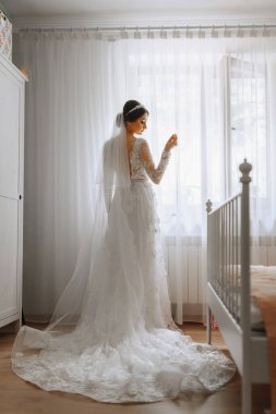Pencerenin yanındaki bir odada beyaz gelinlik içinde güzel genç bir gelin. Düğün için son hazırlıklar. Gelin, damadı bekliyor. Günaydın, gelin..