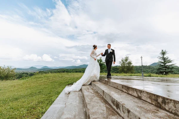Красивая Невеста Свадебном Платье Красивой Прической Женихом Черном Костюме Лестнице — стоковое фото