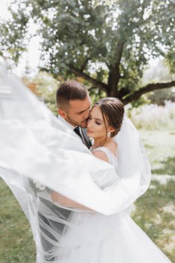 Gelin ve damat düğün töreninden sonra yürür. Bahçede yürüyen genç bir çift. fotoğraf doğada, ormanda, doğada.