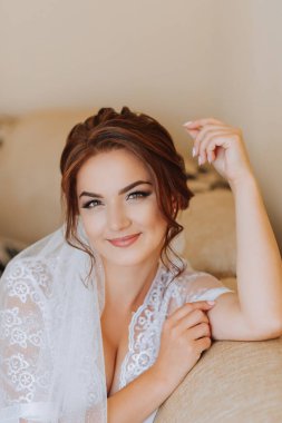 Gelinin elinde kristal olan altın küpeler, yakın plan. Gelinin sabahı