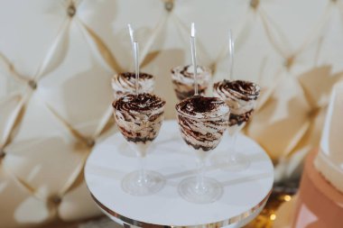 Lezzetli bir düğün. Çiçeklerle süslenmiş beyaz pasta. Şölen için çikolata. Kutlama konsepti. Modaya uygun tatlılar. Şekerli, şekerli bir masa. Meyveler