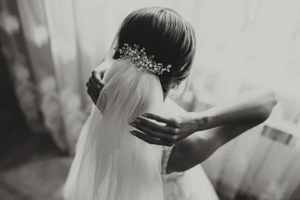 classic bridal hairstyle from behind, close-up, veil secured with handmade tiara.