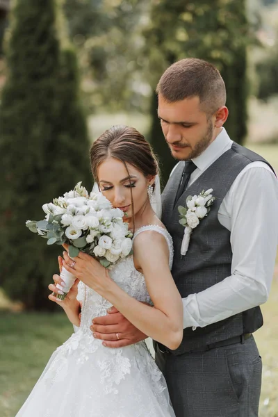 一个美丽的婚礼 一对恋爱中的美丽的夫妇 在一个绿色花园的背景下欢笑和亲吻 高质量的照片 — 图库照片