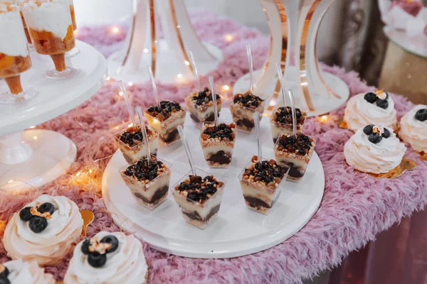スイーツと一緒にお祝いのデザートテーブル 結婚式のキャンディーバー 様々なケーキ スタンド上のチョコレート — ストック写真