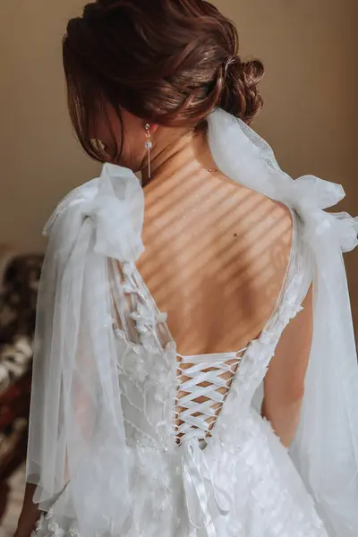 ウェディングドレスを着た花嫁のオープンな美しい肩の写真 エレガントな髪型 ブラウン ボリュームベール 朝から花嫁 — ストック写真