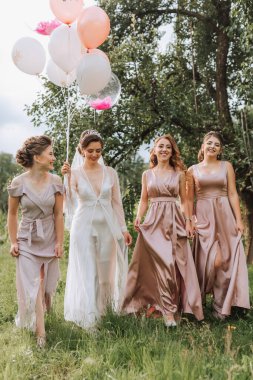 Nedimeler gülümseyen geline bakarlar. Gelin ve eğlenceli arkadaşları dışarıda, aynı elbiselerle bir bekarlığa veda partisini kutluyorlar. Gelin ve arkadaşlar açık gökyüzünün altındaki çimlerin üzerinde
