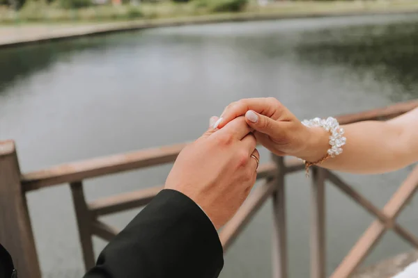 Γαμπρός Κρατά Απαλά Χέρι Της Νύφης Στο Φόντο Της Λίμνης — Φωτογραφία Αρχείου
