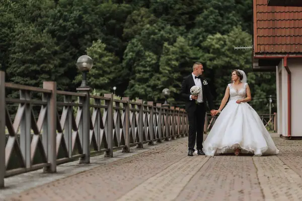 Брюнетка Невеста Длинном Платье Жених Классическом Костюме Идут Мосту Возле — стоковое фото