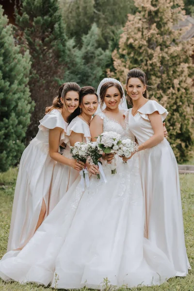 同じドレスで花嫁と一緒にいる美しい女の子のグループは 自然と背の高い木の背景と一緒に笑顔 楽しんでいます ガールズパーティー — ストック写真