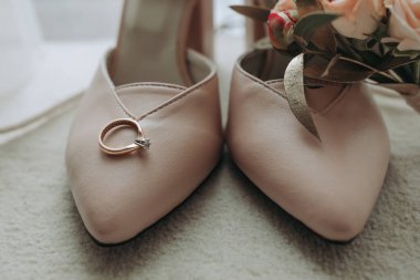 Bej rengi açık şık ayakkabılar. Elmaslı bir alyans, güllerden yapılmış bir alyans. Moda. Tarz. Düğün fotoğrafı.