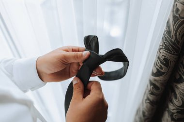 Şık bir damat düğün töreni için hazırlanıyor. Damat sabahı. Otelde beyaz gömlekli bir iş adamı, erkek eli kapalı, damat düğün töreninden önce hazırlanıyor.