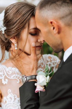 Genç düğün çifti, sonbahar parkında güneşin altında romantik anların tadını çıkarıyor.