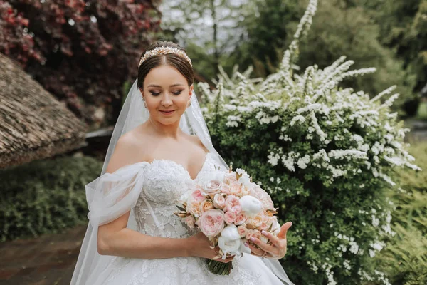白いウェディングドレスの美しい花嫁の肖像画 モダンなヘアスタイルと庭を歩くベール付きの長い列車 ウェディングコンセプト — ストック写真