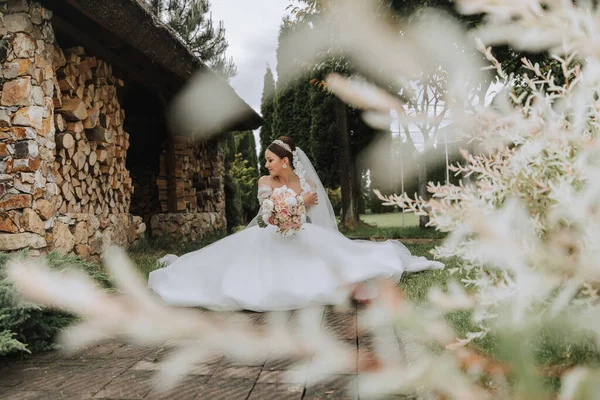 白いウェディングドレスの美しい花嫁の肖像画 モダンなヘアスタイルと庭を歩くベール付きの長い列車 ウェディングコンセプト — ストック写真
