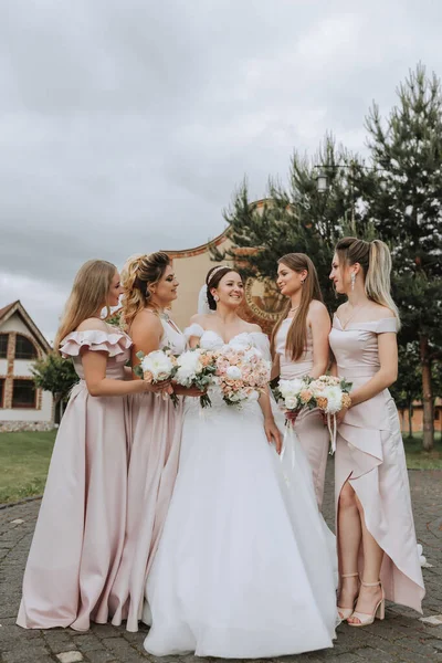 新娘和伴娘们开心的集体画像 婚礼当天 穿着婚纱的新娘和穿着粉色礼服的朋友们 色彩艳丽的婚礼 婚姻的概念 — 图库照片