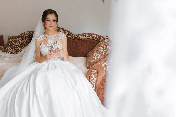 Gelin Kanepede Bir Gelinlikle Oturuyor Elinde Bir Yaka Çiçeğiyle Düğün — Stok fotoğraf
