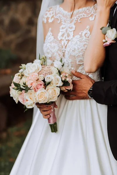 白いドレスでかわいいブルネットの花嫁と屋外で抱擁する花の花束 結婚式の写真 新婚旅行の笑顔の肖像画 — ストック写真