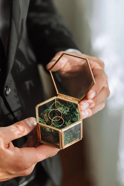 結婚指輪は緑色のモスの美しいガラスの箱に横たわっています 朝のミーティング中の動詞の詳細 — ストック写真