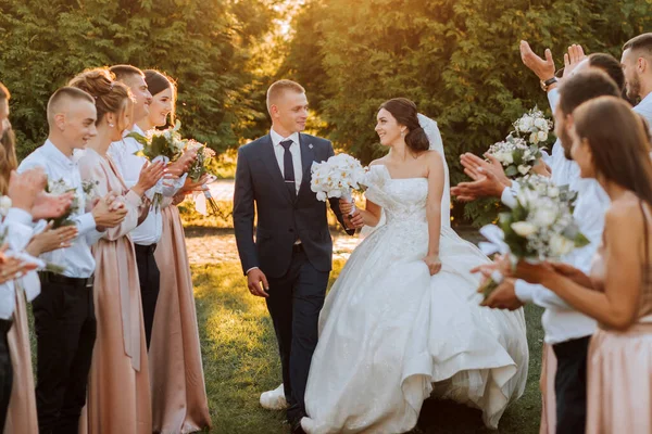 友人や家族が祝うように日没の結婚式の後に通路を歩いた花嫁とグルーミングの広い角度ショット — ストック写真