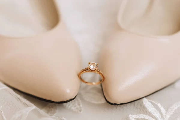 Μπεζ Κομψά Παπούτσια Ένα Διαμαντένιο Δαχτυλίδι Αρραβώνων Κάθεται Ανάμεσα Ένα — Φωτογραφία Αρχείου