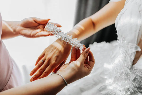 婚礼的主题 一个朋友给新娘戴上了一个手镯 婚礼准备工作的最后一分钟同一套衣服手工珠宝 — 图库照片