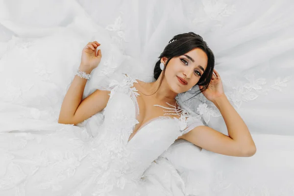 穿着婚纱的年轻漂亮的新娘躺在地上 时尚极了 这张照片是在上面拍的 在婚纱附近一个梦幻般的新娘正在享受她的婚礼 — 图库照片