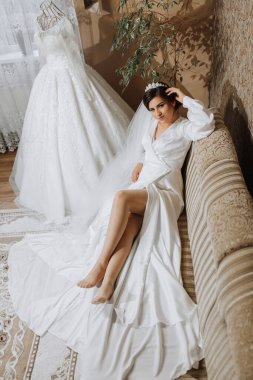 Gelinin sabahının romantik atmosferi. Bakımevinde gelin. Gelin sabahı hazırlığı. Mankenin yanında güzel elbiseli bir gelin ve evde elbisesi var. Her anın tadını çıkar