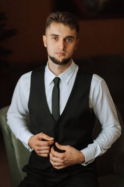 Sakallı şık bir damat düğün törenine hazırlanıyor. Damat sabahı. İş adamı yaban mersini yeleği giyer. Damat düğün töreninden önce hazırlanıyor.