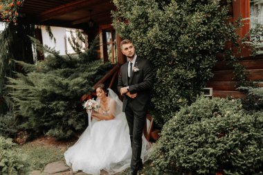 Rüzgarda süzülen duvağı olan zarif, zarif bir gelin. Ve şık bir damat uzun sonbahar ağaçlarının yanında dışarıda öpüşüyor.