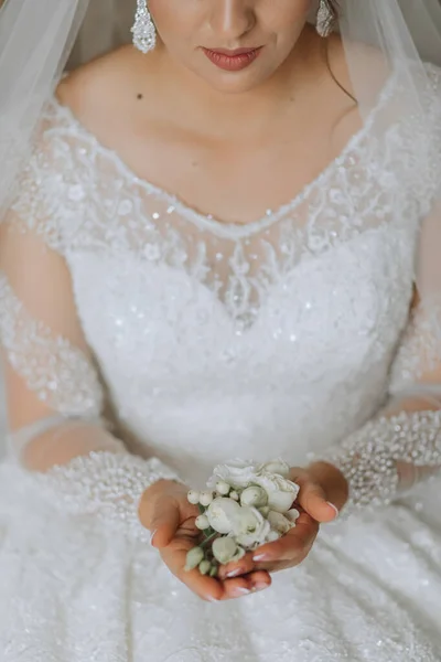 the bride holds the groom's flower in her hands. wedding flowers