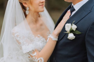 Ormanda ya da parkta şefkatle kucaklaşan zarif bir çiftin portresi. Lüks gelin ve damat kucaklaşması. Romantik şehvetli an