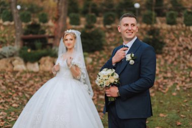 Ormanda ya da parkta şefkatle kucaklaşan zarif bir çiftin portresi. Lüks gelin ve damat kucaklaşması. Romantik şehvetli an