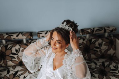 Bornozuyla taç takan muhteşem gelin portresi. Güzel makyaj, saç stili ve saç aksesuarları. Gelin gülümseyen portre olacak