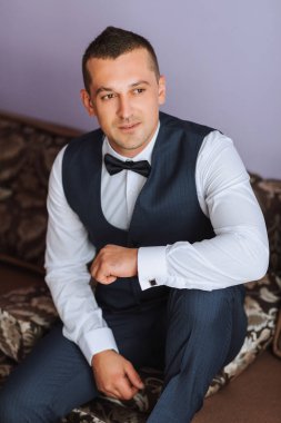Nişanlısının portresi. Odasında yelek giyip düğüne hazırlanıyor. Adam iş günü için hazırlanıyor..