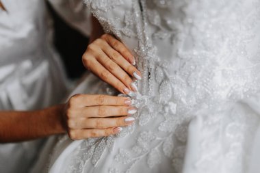 Güzel çıplak manikür. Uzun badem şekilli tırnaklar. Tırnak tasarımı. Manikür ve jöle. Tırnaklarında hafif çıplak manikür olan genç bir kadının ellerine yakın çekim. Jöle ojeli parlak tırnaklar