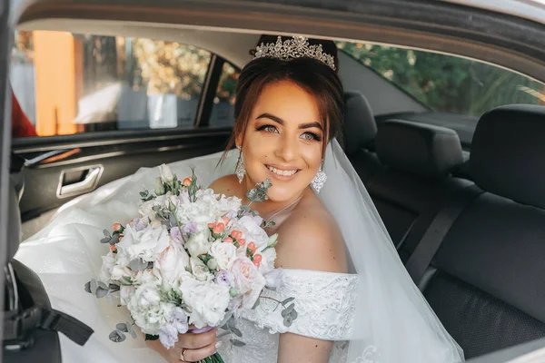Eine Schöne Lächelnde Braut Sitzt Ihrem Hochzeitstag Auto Und Hält — Stockfoto